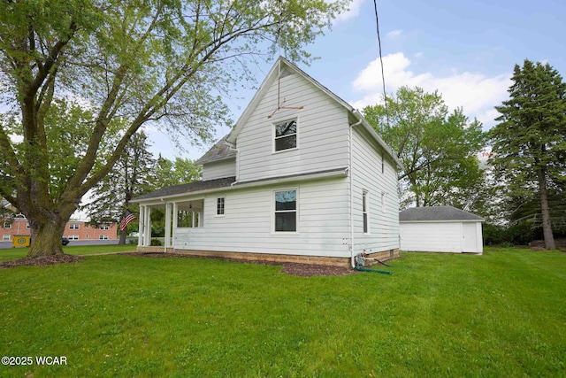 rear view of property featuring a lawn and a garage