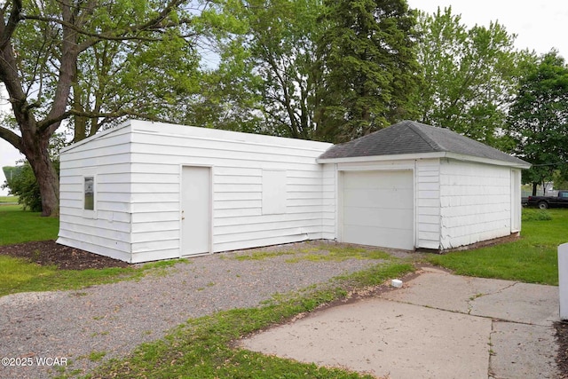 detached garage with asphalt driveway