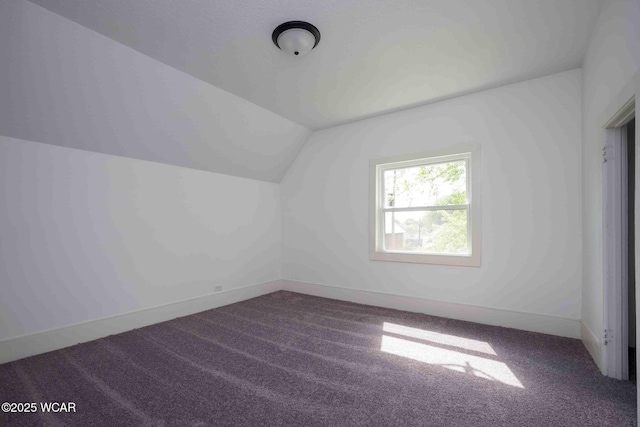 additional living space featuring lofted ceiling and carpet