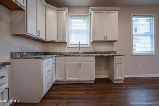 kitchen featuring white cabinetry, dark wood-type flooring, sink, and dark stone countertops