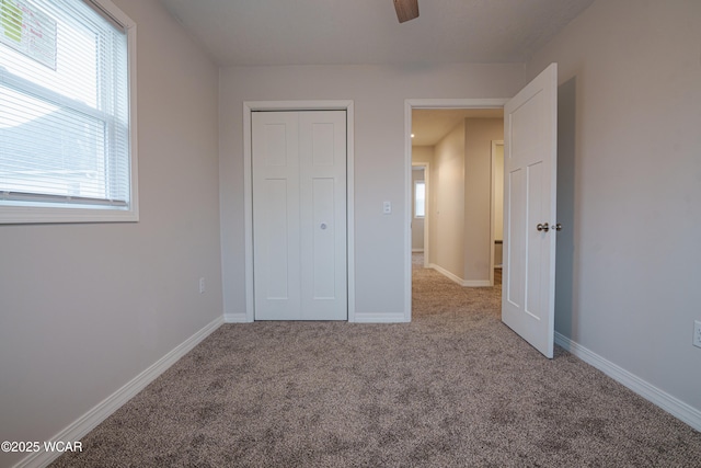 unfurnished bedroom featuring ceiling fan, a closet, and light carpet