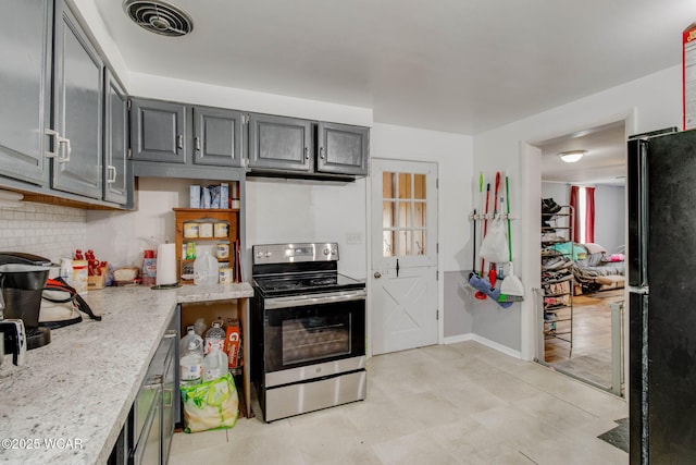 608 W Pearl St, Wapakoneta, OH 45895 - kitchen with freestanding refrigerator, visible vents, backsplash, stainless steel electric range oven, and light stone counters