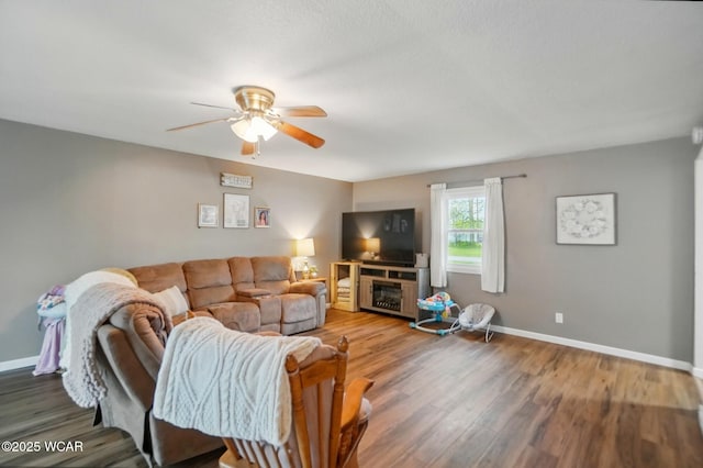 living area with ceiling fan, baseboards, and wood finished floors