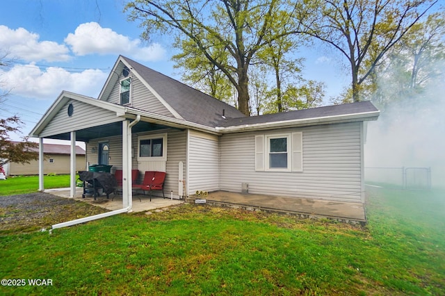 rear view of house featuring a yard and a patio area