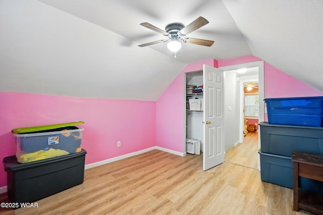 additional living space featuring wood finished floors, baseboards, ceiling fan, and lofted ceiling