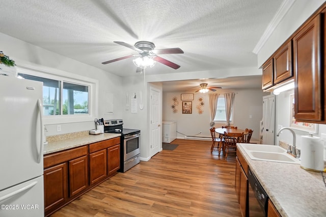 kitchen with a sink, freestanding refrigerator, light wood-type flooring, ceiling fan, and electric stove