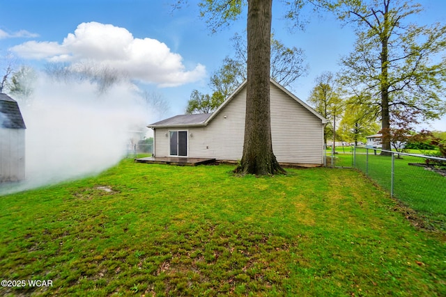 rear view of property with a yard, a deck, and fence