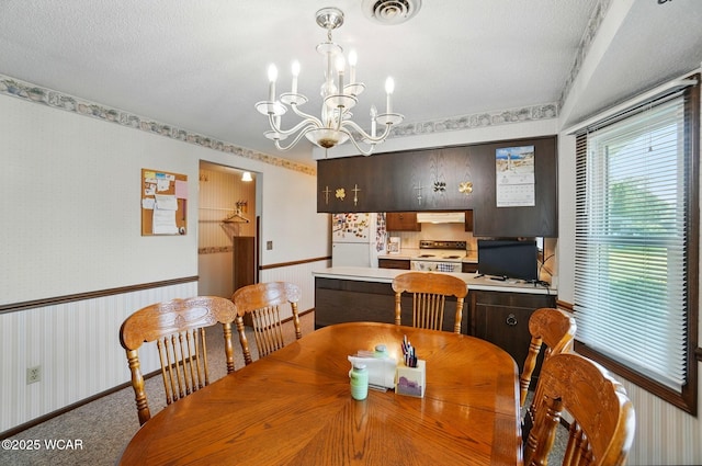 1317 Larry St, Van Wert, OH 45891 - carpeted dining space with wallpapered walls and a chandelier
