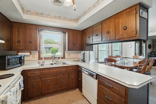 1317 Larry St, Van Wert, OH 45891 - kitchen featuring white appliances, a peninsula, light countertops, and brown cabinets