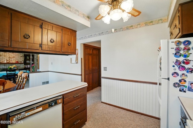 1317 Larry St, Van Wert, OH 45891 - kitchen featuring white appliances, a ceiling fan, brown cabinets, light countertops, and light carpet
