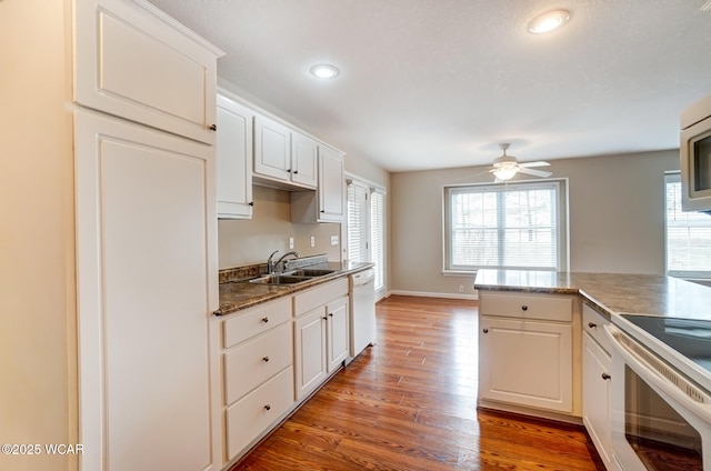 kitchen with light wood-style floors, white appliances, a healthy amount of sunlight, and a sink