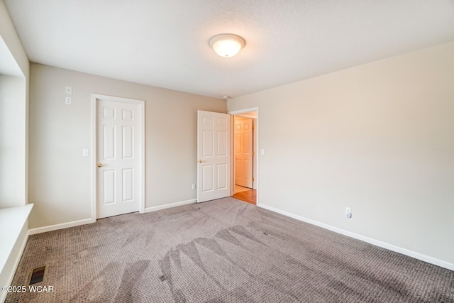 unfurnished bedroom with carpet and baseboards