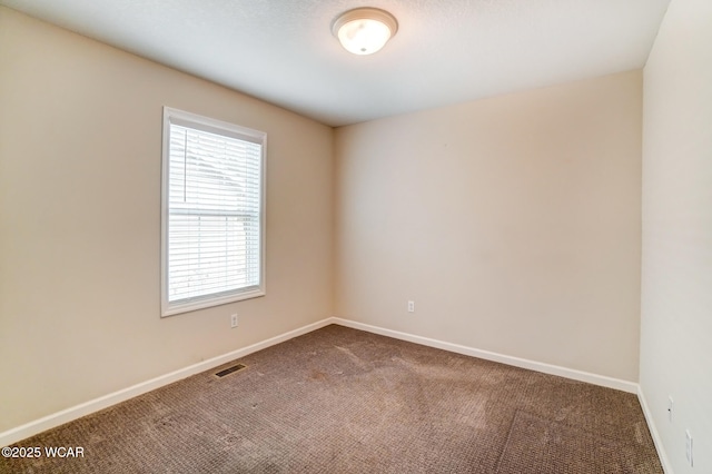 unfurnished room with carpet floors, baseboards, and visible vents