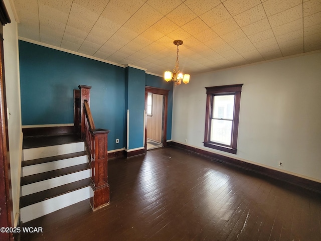 interior space featuring dark hardwood / wood-style flooring, ornamental molding, and an inviting chandelier