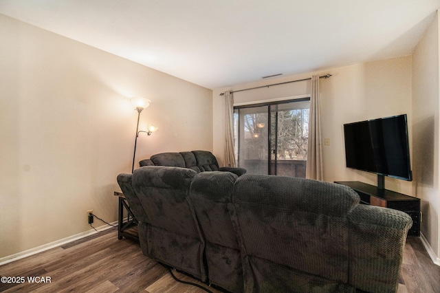 living room featuring visible vents, baseboards, and wood finished floors