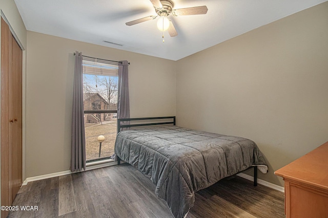 bedroom featuring baseboards, a closet, visible vents, and wood finished floors