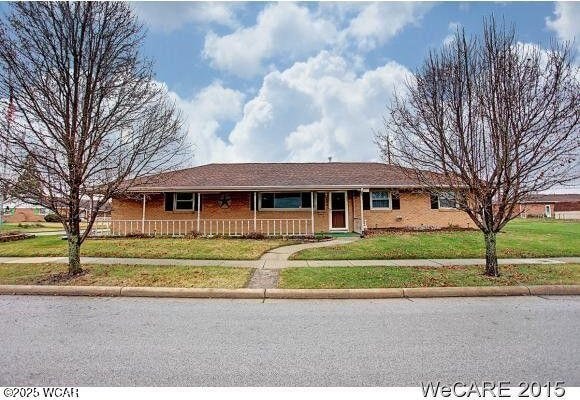 ranch-style home featuring brick siding and a front lawn