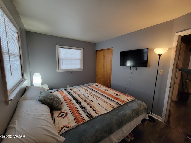 bedroom with a closet, baseboards, and wood finished floors