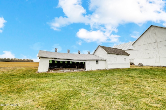 rear view of house featuring an outbuilding and a lawn