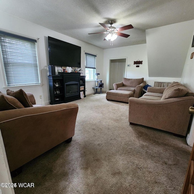 living room featuring ceiling fan, carpet floors, and a textured ceiling