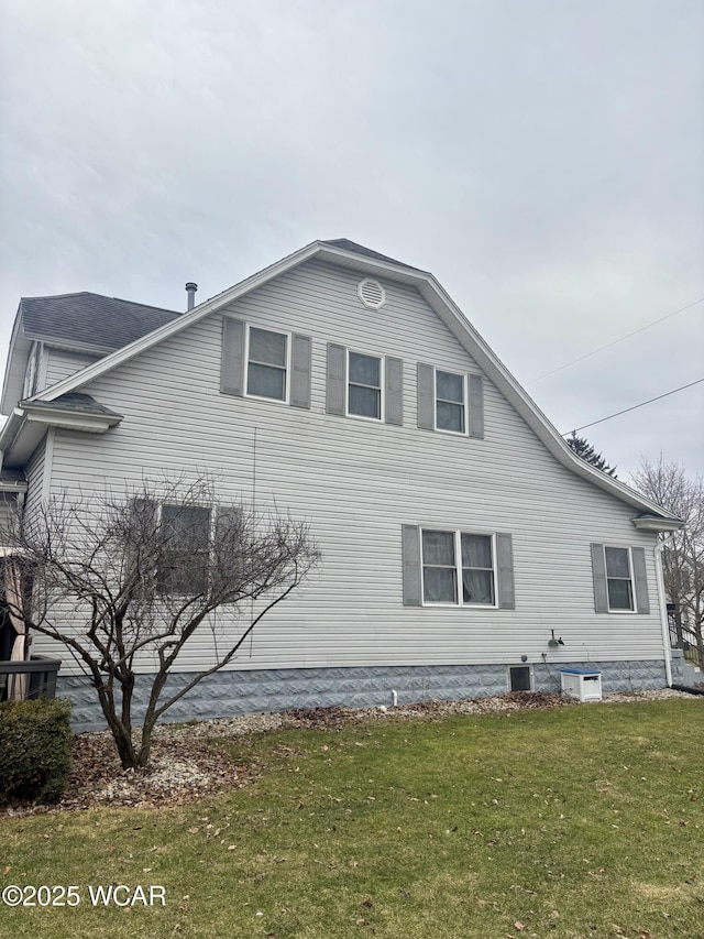 view of side of property featuring central AC and a yard