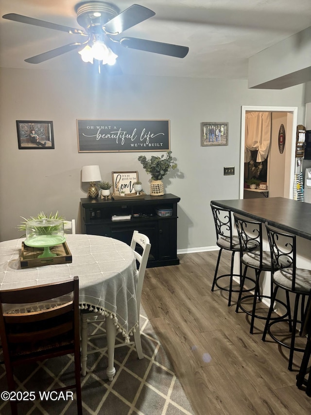 dining area featuring ceiling fan and dark hardwood / wood-style flooring