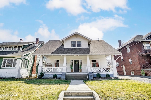 bungalow-style house featuring covered porch, a front yard, and a shingled roof