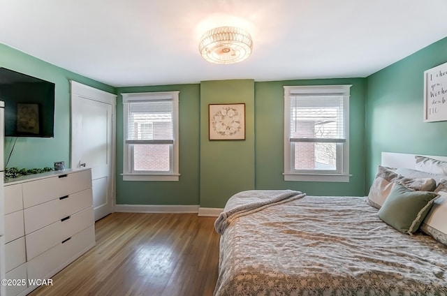 bedroom with baseboards and wood finished floors