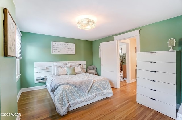 bedroom with light wood finished floors and baseboards