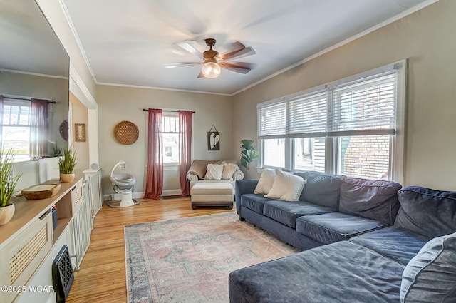 living room featuring ceiling fan, baseboards, light wood-style floors, and ornamental molding