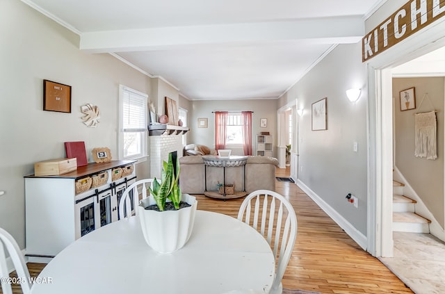 dining area featuring stairs, light wood-style flooring, baseboards, and ornamental molding