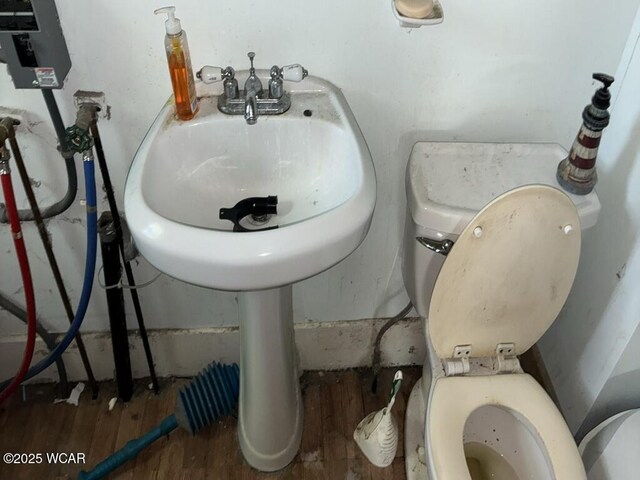 1027 W Elm St, Lima, OH 45805 - half bath featuring wood finished floors and toilet