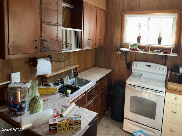 1027 W Elm St, Lima, OH 45805 - kitchen featuring white range with electric stovetop, light countertops, wooden walls, and a sink