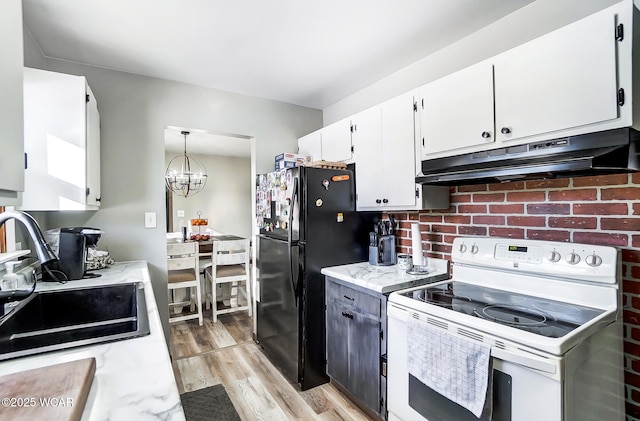 kitchen featuring pendant lighting, sink, white range with electric stovetop, white cabinets, and black fridge