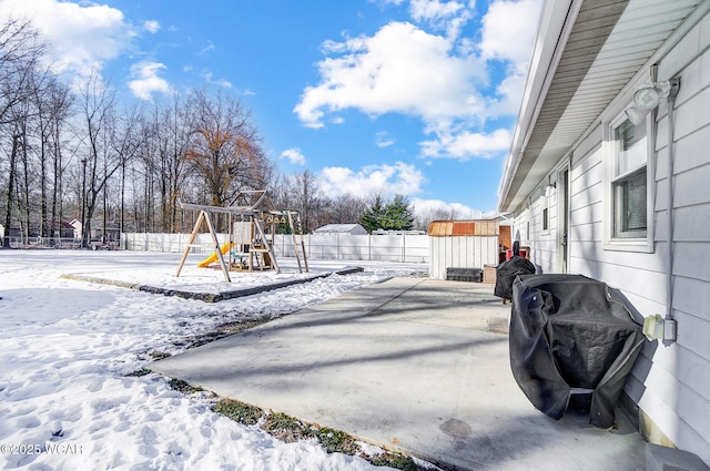 snowy yard featuring a playground