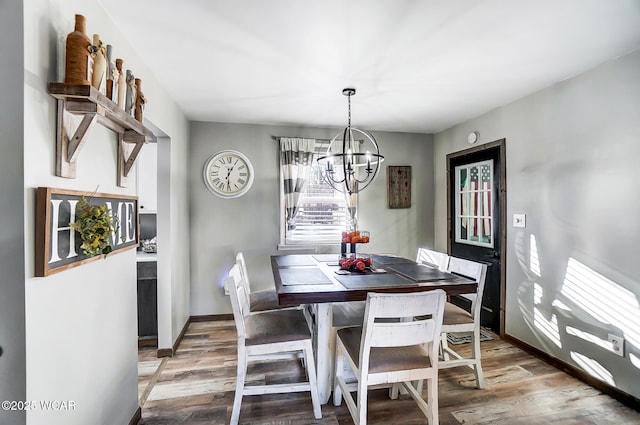 dining space featuring hardwood / wood-style flooring and a notable chandelier