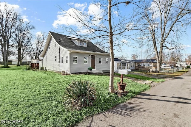 new england style home featuring central air condition unit and a front lawn