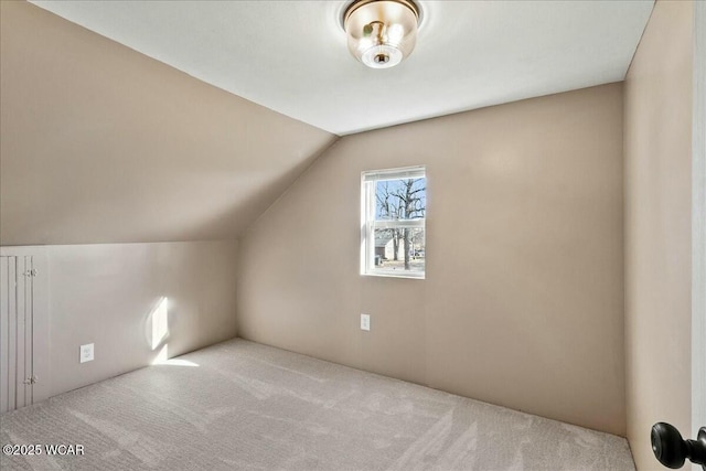 bonus room with vaulted ceiling and light colored carpet