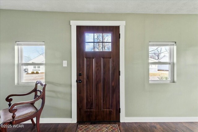 entrance foyer with dark hardwood / wood-style flooring and a textured ceiling