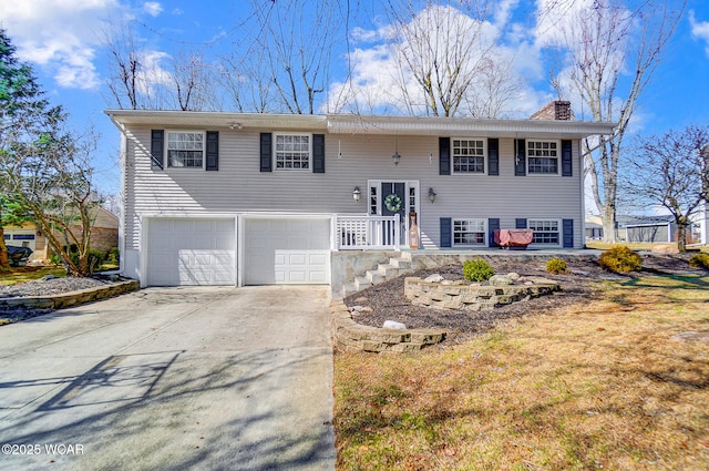 split foyer home with concrete driveway, a garage, and a chimney