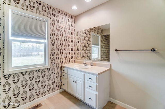 bathroom with plenty of natural light, baseboards, and wallpapered walls