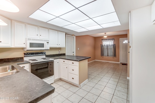 kitchen with a peninsula, white appliances, light tile patterned floors, and white cabinetry