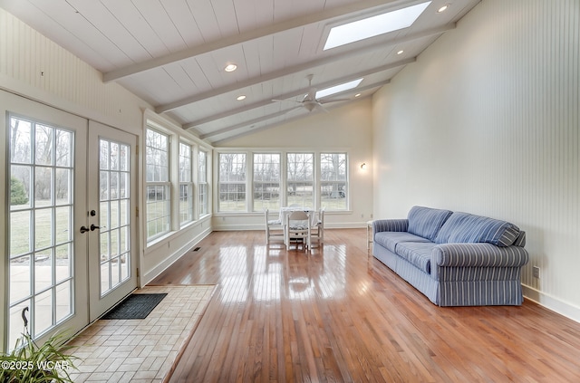 sunroom with a ceiling fan, vaulted ceiling with skylight, french doors, and visible vents