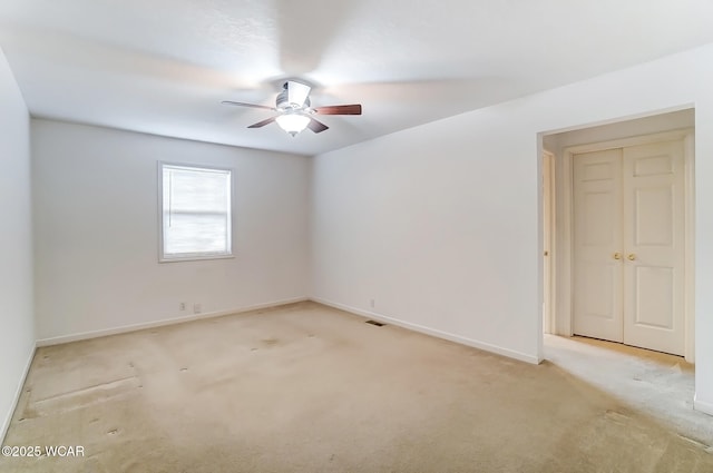 spare room with carpet, ceiling fan, and baseboards