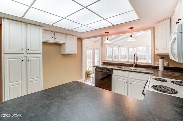 kitchen featuring dark countertops, white appliances, white cabinets, and a sink