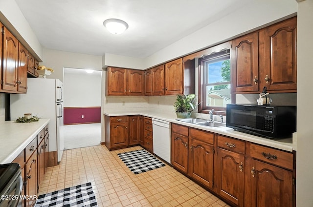 1619 Northbrook Dr, Lima, OH 45805 - kitchen with white appliances, light countertops, brown cabinets, light floors, and light carpet