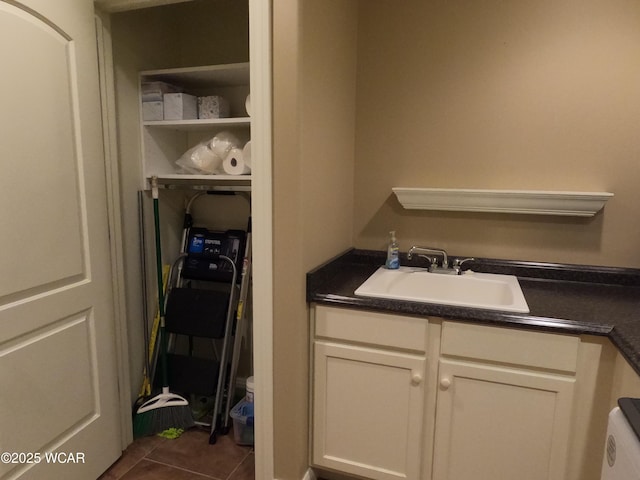 washroom with dark tile patterned floors and sink