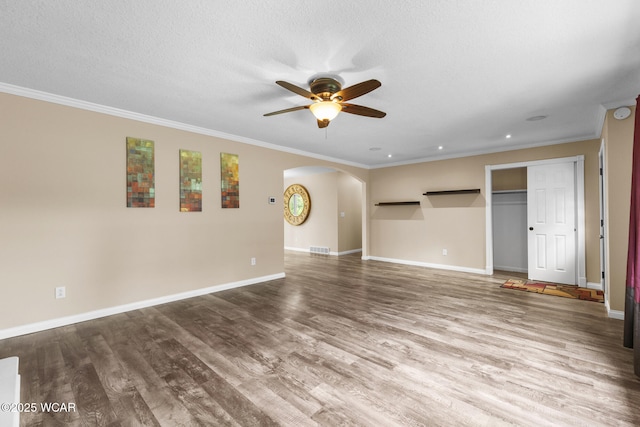 3139 Clifford Dr, Lima, OH 45805 - unfurnished living room featuring arched walkways, ceiling fan, crown molding, wood finished floors, and recessed lighting