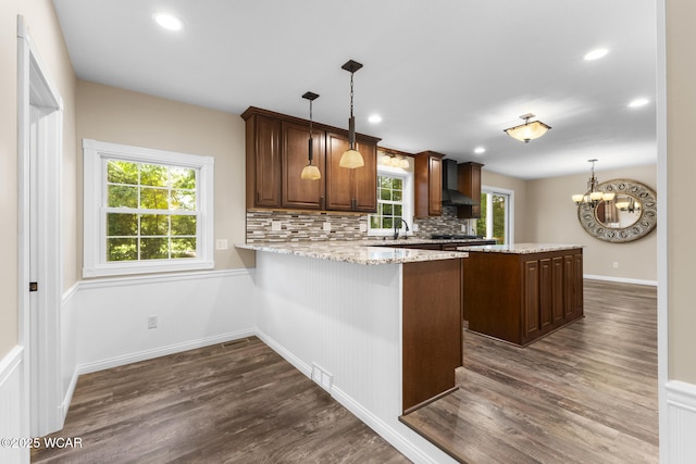 3139 Clifford Dr, Lima, OH 45805 - kitchen featuring wall chimney range hood, dark wood finished floors, healthy amount of natural light, backsplash, and recessed lighting