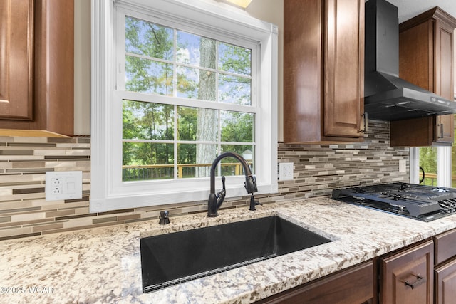 3139 Clifford Dr, Lima, OH 45805 - kitchen with wall chimney range hood, black gas cooktop, tasteful backsplash, and light stone counters